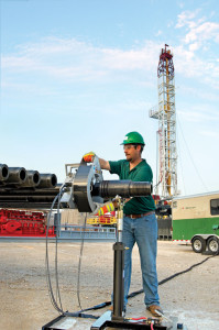 An NOV Tuboscope technician inspects drill pipe on a rig site; the service is typically performed after every other well. 