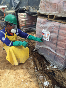 A worker preparing to mix chemicals reviews the label to identify any physical or health hazards before working with the chemical on Parker Drilling Rig 271 in Colombia.